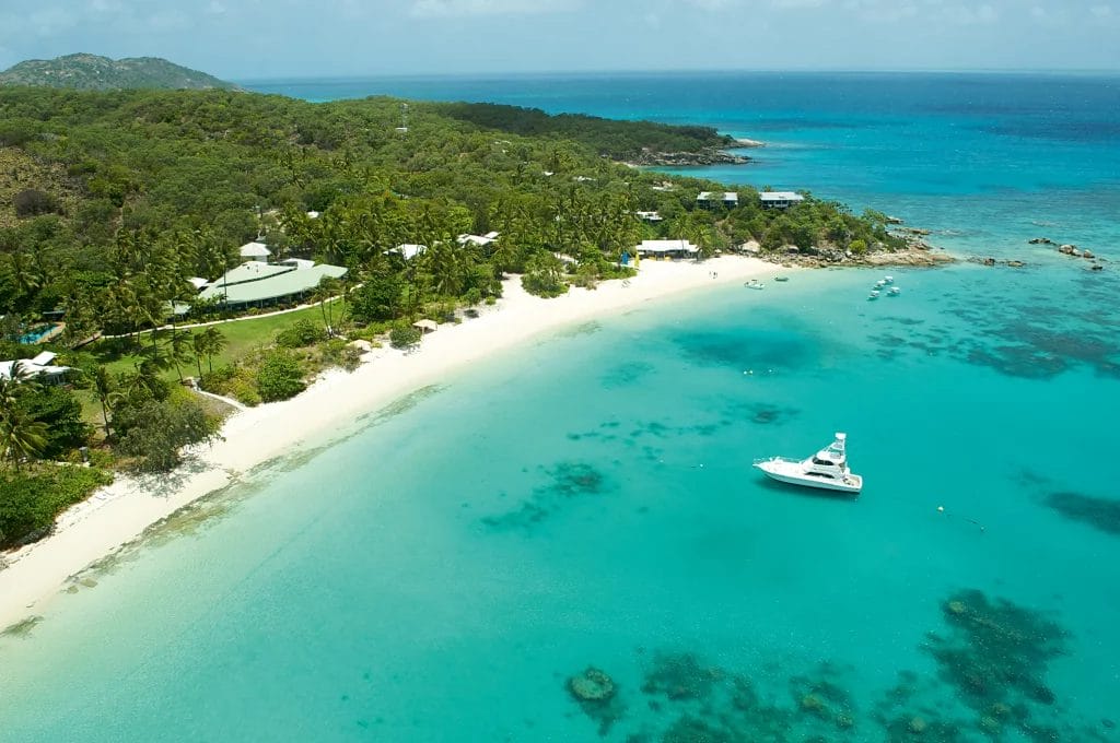 Lizard Island resort where forest and coastline meet, with crystal-clear waters filled with yachts