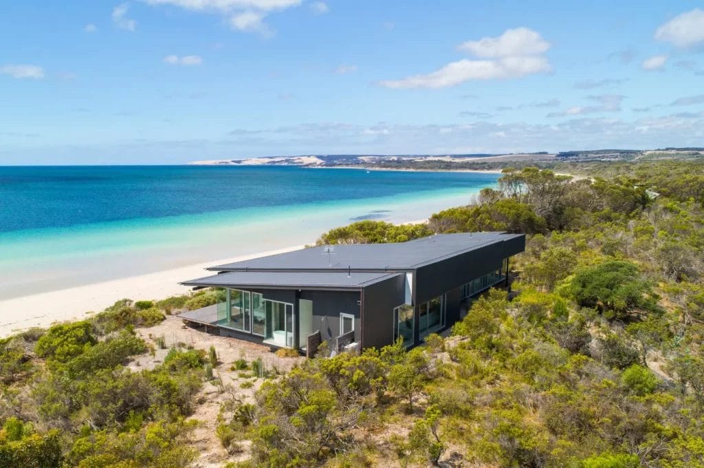 Exterior of private home One Kangaroo Island nestled amongst bush overlooking a white sand beach