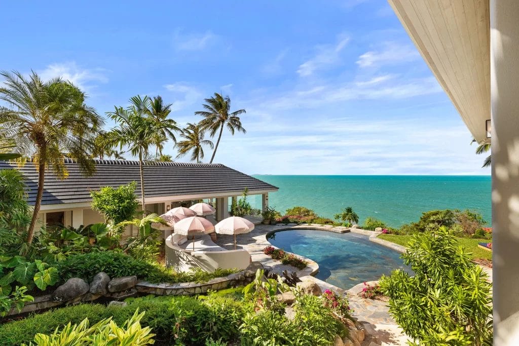 Views of Port Douglas Private Home’s heated in-ground pool, tropical gardens, and master suite with views over the Coral Sea
