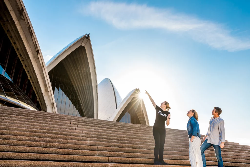 Guests being shown around the exterior of the Sydney Opera House by a guide