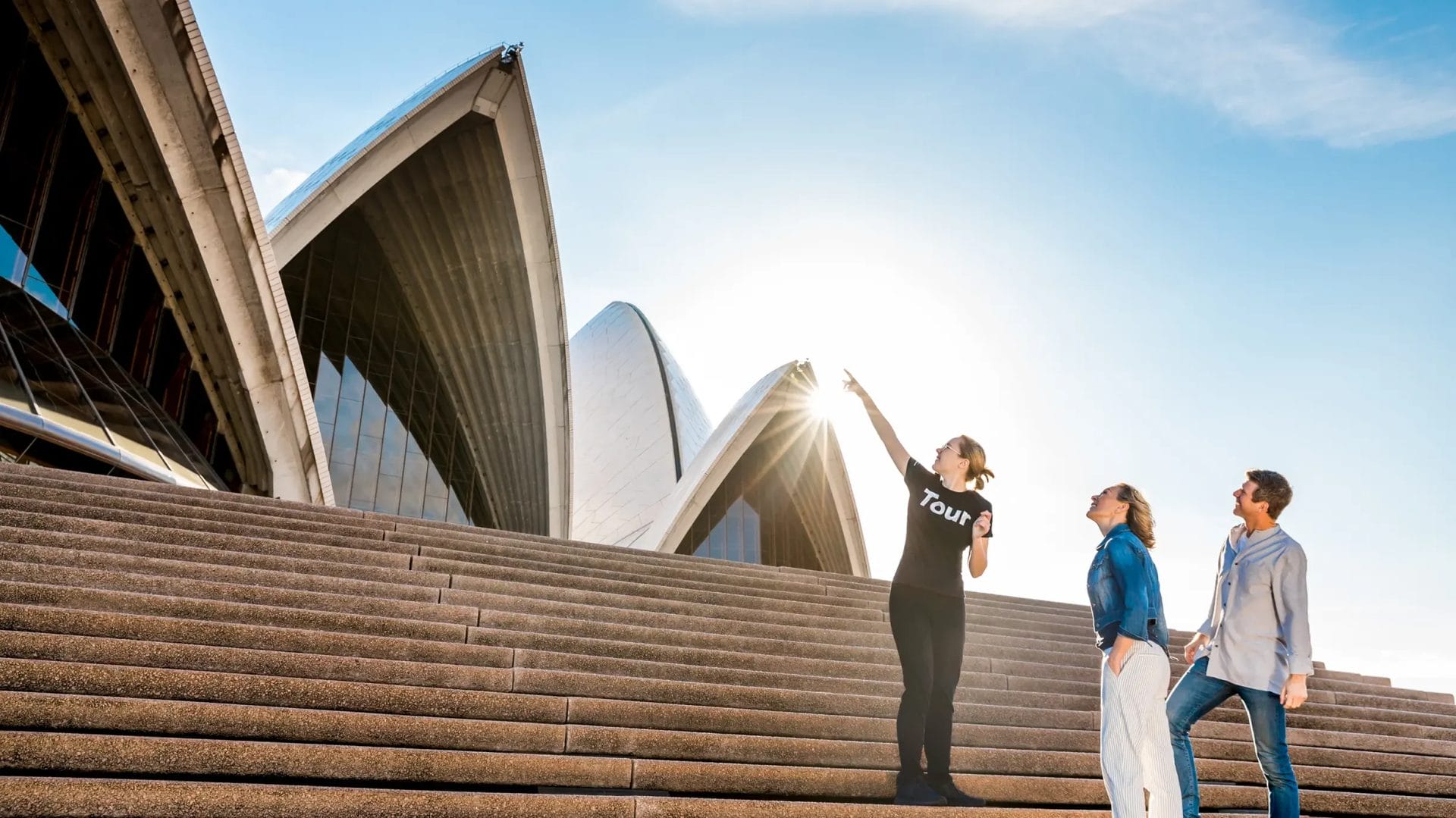 Guests being shown around the exterior of the Sydney Opera House by a guide